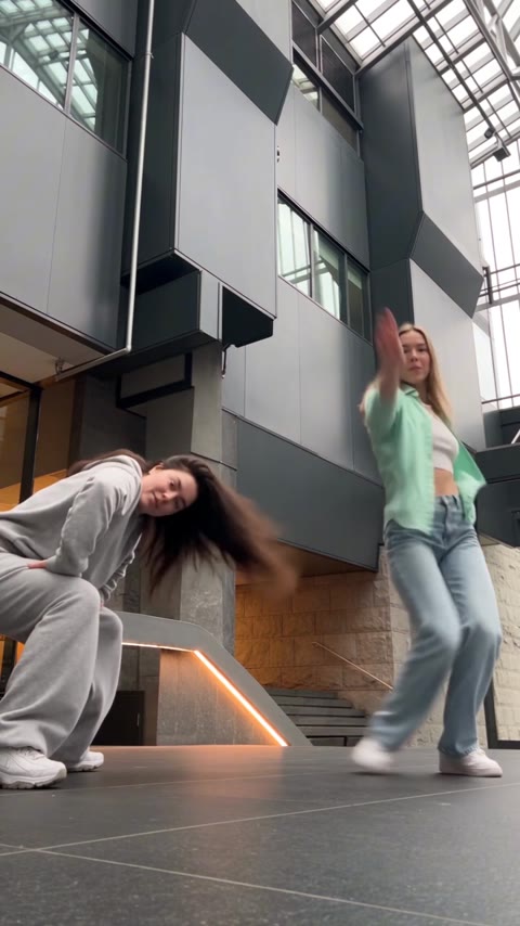 NEON dance lead bending sideways as her partner stretches one arm upward