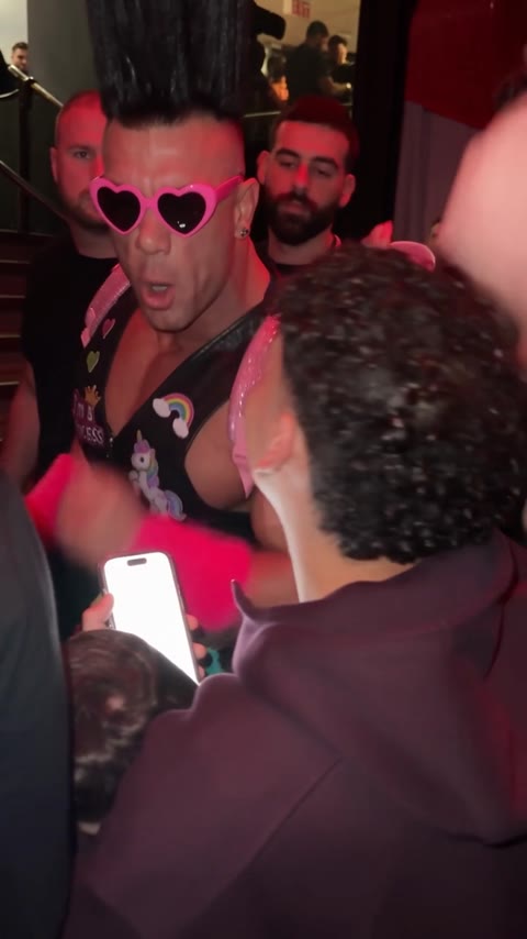 Bulin 47 AI Video performer facing a man holding a phone in the club crowd