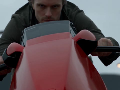 Crazy Frog Chase AI close-up of a man gripping handlebars behind a red front panel