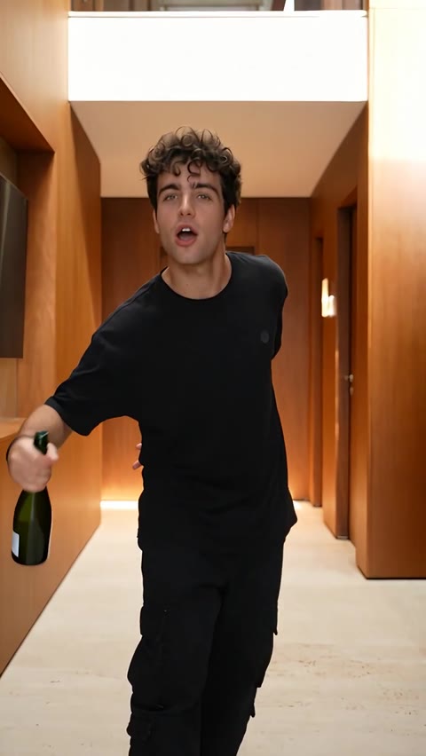 Popstar AI Video man extending the bottle toward the camera in the corridor