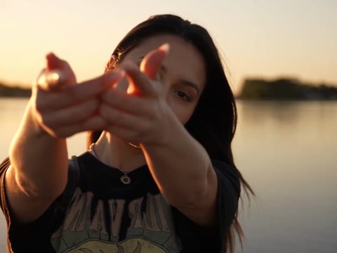 Raindance AI closing with a woman reaching both hands toward the camera by the lake