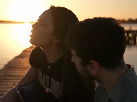 Raindance AI partners sitting close together with sunset light reflected across the lake