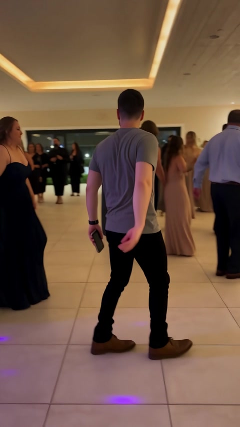 Man in a gray T-shirt turning his back to the camera on a banquet floor